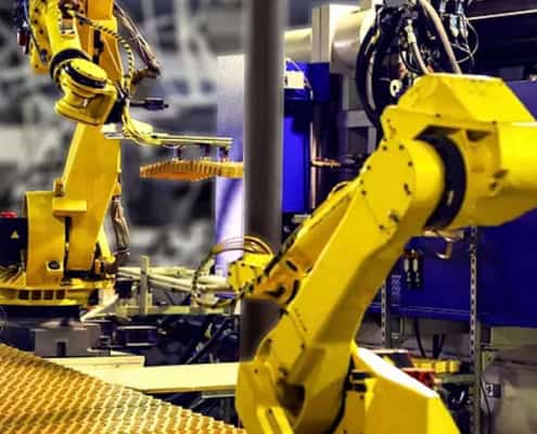 Sistema de automatización robótica, con dos brazos robóticos industriales de color amarillo en un entorno de fábrica