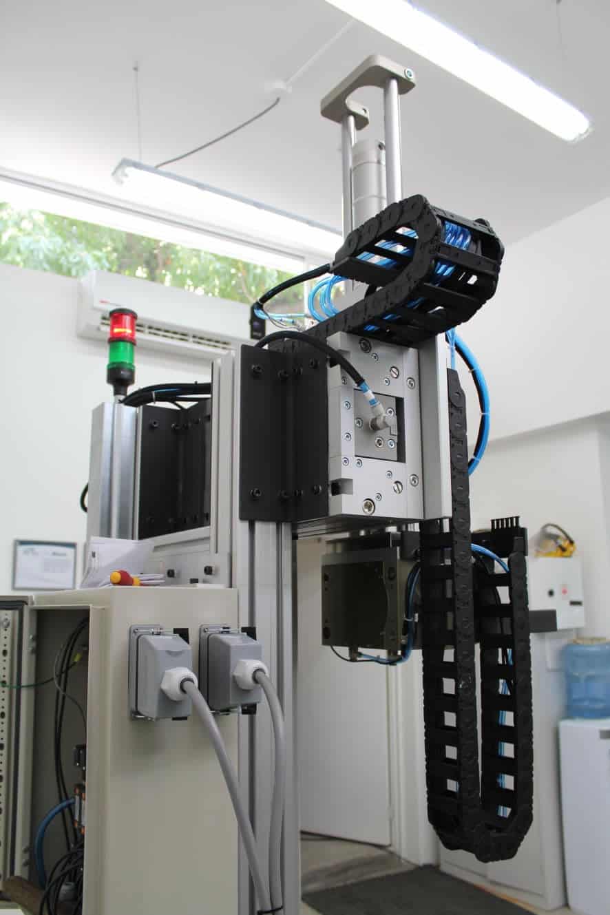 Brazo robótico o un sistema de movimiento lineal montado en un marco de aluminio.